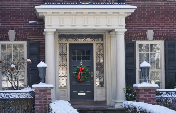 传统的老式砖房，入口有门廊，前门有圣诞装饰图片下载