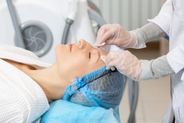 照片的专业女性美容师使用海绵洗脸的一个女性客户准备美容程序。返老还童和保湿程序图片下载