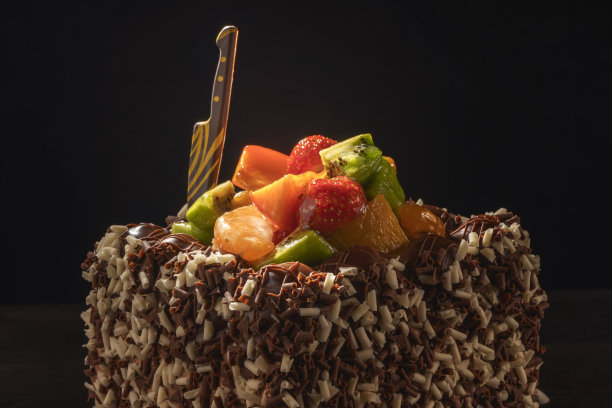 巧克力和水果蛋糕。黑色背景图片下载