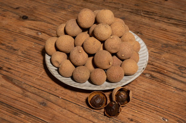 容器里的龙眼干放在木纹桌上图片下载