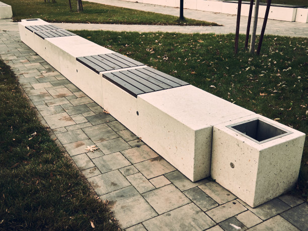 公园里的长椅是用石头和木板做成的，附近有一个石缸图片下载