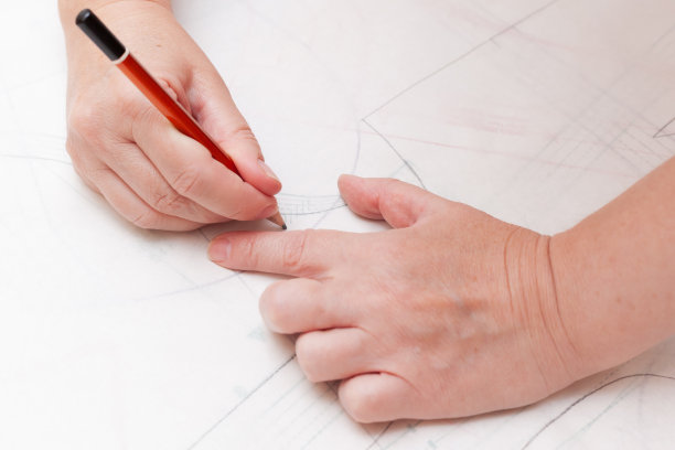 女性设计师画平纸模式。专属服装制作概念。图片下载