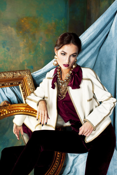 美丽富有的黑发女人在豪华的内饰附近空框，穿着时尚的衣服，生活方式的人的概念图片下载