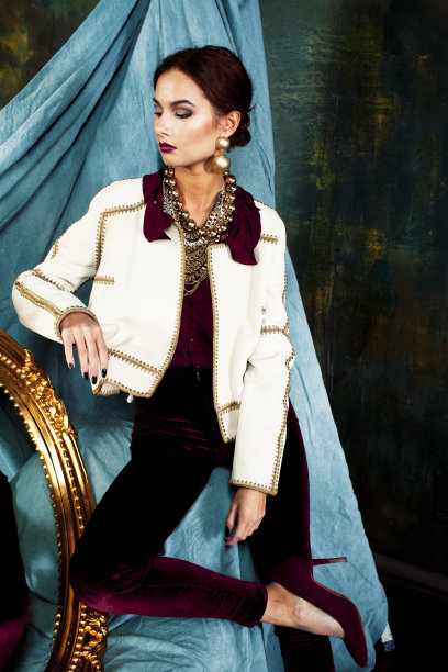 美丽富有的黑发女人在豪华的内饰附近空框，穿着时尚的衣服，生活方式的人的概念图片下载