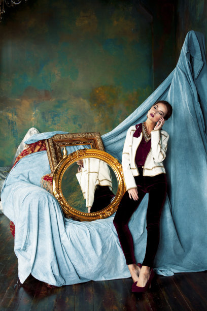 美丽富有的黑发女人在豪华的内饰附近空框，穿着时尚的衣服，生活方式的人的概念图片下载