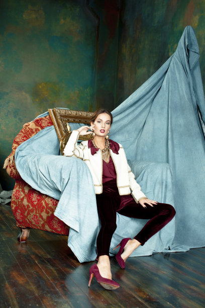 美丽富有的黑发女人在豪华的内饰附近空框，穿着时尚的衣服，生活方式的人的概念图片下载