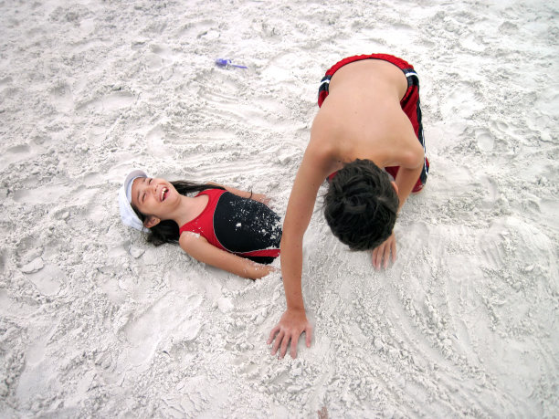 靠近两个在热带沙滩上玩耍的孩子图片下载