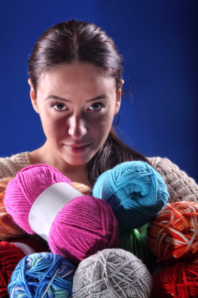 美丽的黑发女人的肖像，拿着一束彩色的羊毛球图片下载