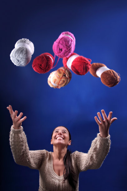 美丽的黑发女人的肖像，拿着一束彩色的羊毛球图片下载