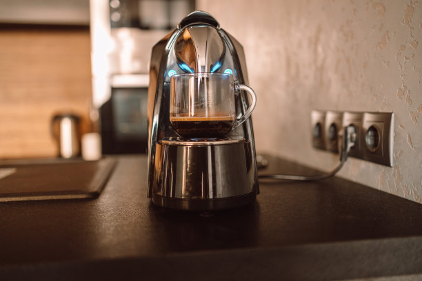 舒适的家庭书桌与现代咖啡机，杯子。早餐图片下载