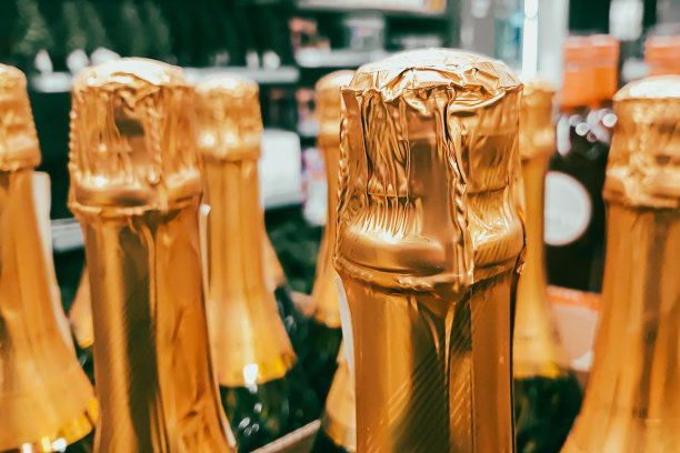 商店里有很多香槟瓶。假日前出售酒精饮料。关闭瓶颈。图片下载