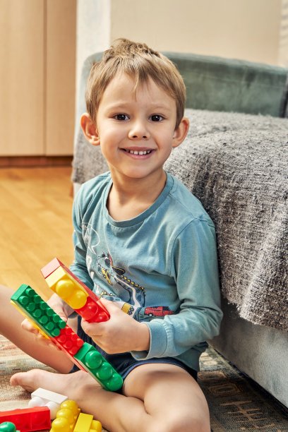 小男孩把构造器细节放在沙发附近的地板上图片下载