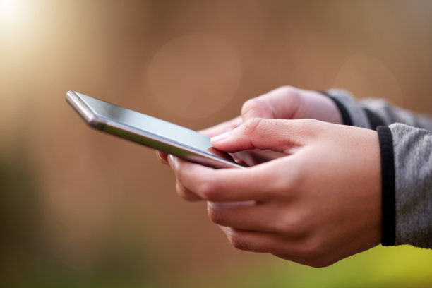 剪裁的照片，一个不认识的女人用她的手机站在外面图片下载