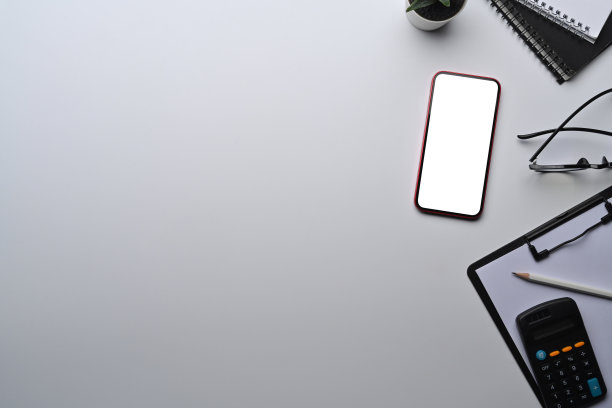 在白色的办公桌上模拟智能手机、计算器、剪贴板和眼镜。图片下载