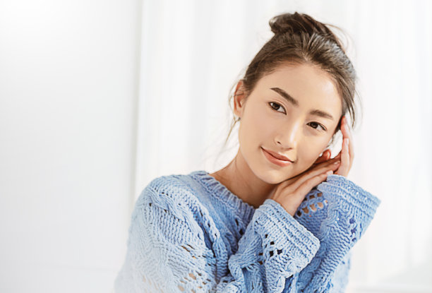 美丽的亚洲女人肖像放松脸在冬季卧室。特写性感美女时尚女孩健康化妆美容完美焕发肌肤。微笑快乐hygge亚洲韩国女孩穿蓝色毛衣图片下载