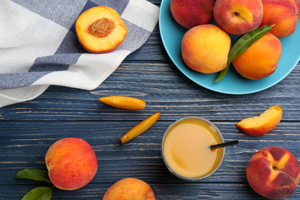 蓝色木桌上放着天然桃汁和鲜果，平放图片下载