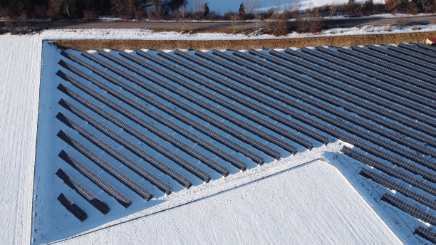 冬季用无人机鸟瞰草地上的大型太阳能农场图片下载