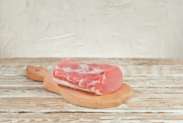 生牛排放在木板上。白色木制背景上的肉。破旧的桌子上放着食物。图片下载