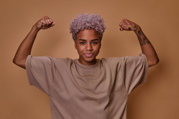 年轻的非洲裔美国女性模特举起手臂，展示力量图片下载