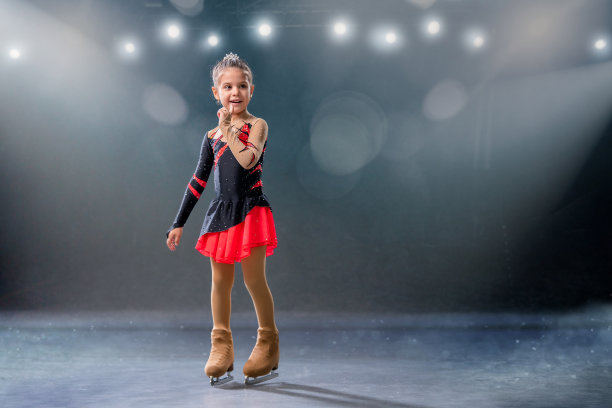 小滑冰者穿着红黑相间的衣服在冰场上玩环图片下载