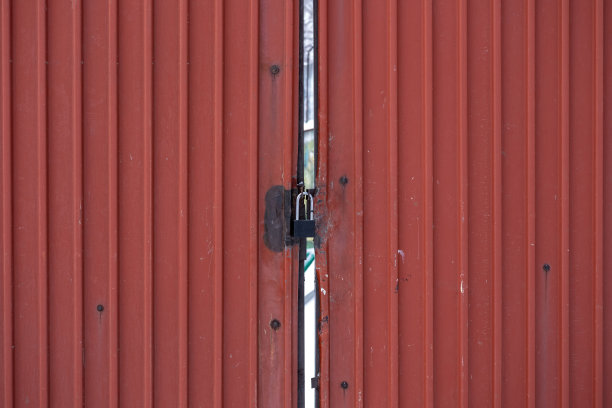 一座生锈的旧铁门上的城堡。关闭工厂。金属的背景。图片下载