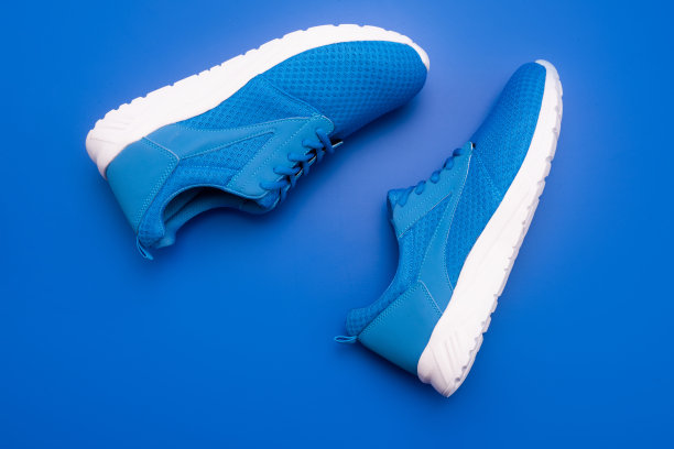 的蓝色的运动鞋。蓝色背景的鞋子。鞋店。购物的概念。图片下载