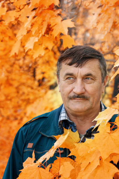 一个男人的街头肖像。图为，在阴天的秋日，一位中年男子的特写镜头。一个成熟，友好的男人的肖像。秋天街上快乐的老人图片下载