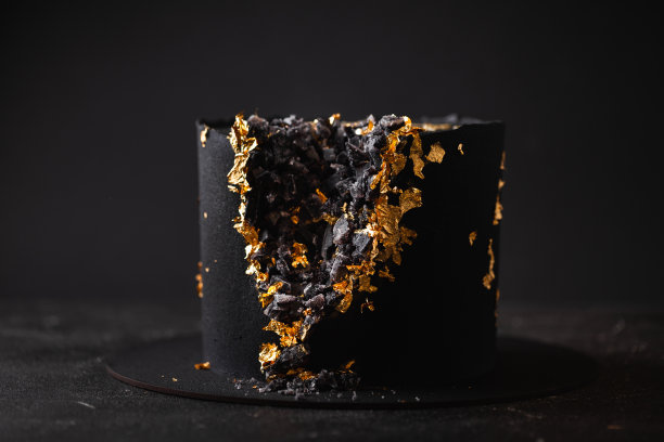 黑色奢华的慕斯蛋糕，上面覆盖着天鹅绒涂层，装饰着金色的花瓣图片下载