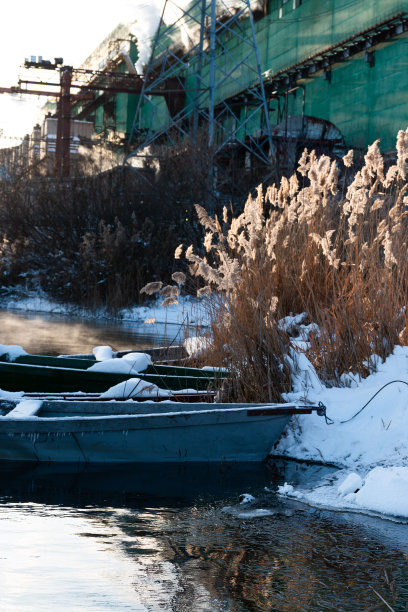 冬天的风景。一个美丽的阳光明媚的冬日湖面上。冬天湖面上的小船。冬天，一艘孤零零的船，被雪覆盖着，停在岸边。图片下载