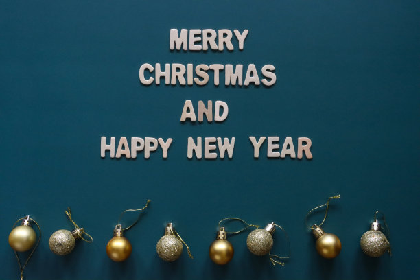 自制DIY简易圣诞卡设计的图像，蓝绿色背景上剪出白色字母，手工制作的圣诞贺卡，圣诞快乐和新年快乐的信息与黄金小饰物图片下载