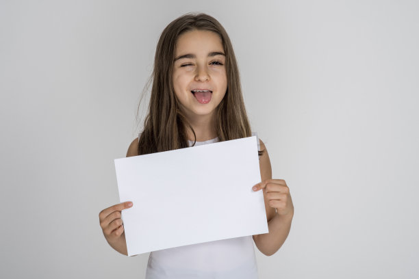 棕色头发的小女孩眨着眼睛，伸出舌头图片下载