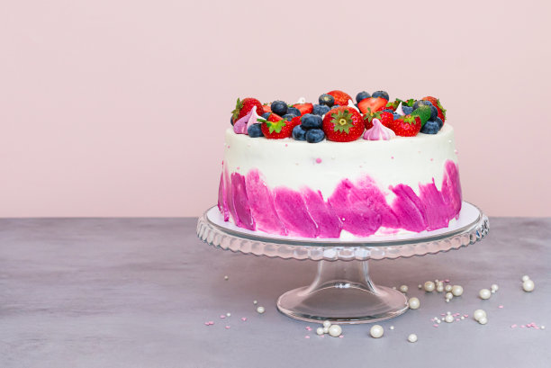 精致的蛋糕装饰着新鲜的浆果，草莓和蓝莓在一个简单的背景图片下载