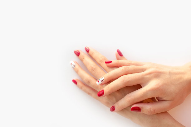 红色的冬季指甲与可爱的鹿在白色的背景。冬季和圣诞节的时间概念。图片下载