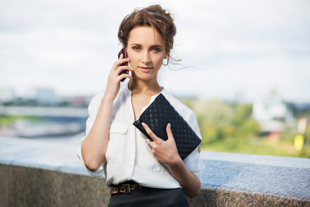 穿着白衬衫的年轻时尚女商人打电话图片下载