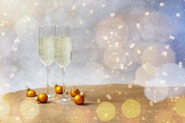 时尚的沙滩上放着香槟酒，酒杯下放着新年玩具，还有许多闪亮的灯光。等待假期图片下载
