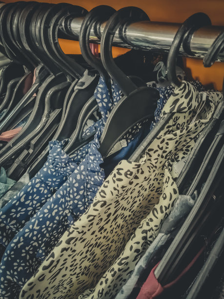 女装挂在商店里那排的衣架上。二手衣服。有选择性的重点图片下载