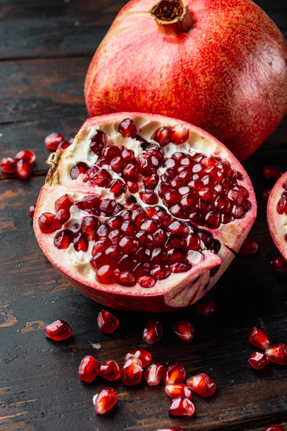 熟石榴和新鲜多汁的籽，放在老木桌上图片下载