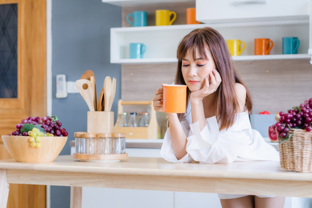 厨房里的年轻女子，享受早晨咖啡图片下载