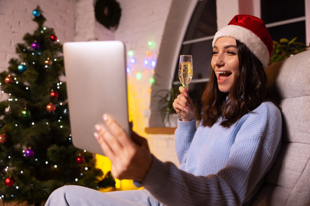 情绪化的小女孩用平板电脑，通过视频通话的方式和朋友聊天。圣诞装饰品回家。图片下载