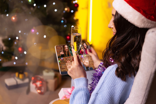 年轻女孩使用平板电脑的后视镜，通过视频通话的方式与朋友交谈。圣诞装饰品回家。图片下载