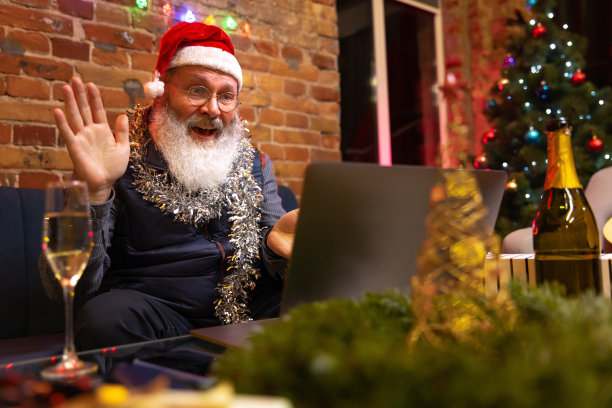 情绪激动的大胡子老人坐在家里，通过视频电话和朋友家人一起庆祝新年。图片下载