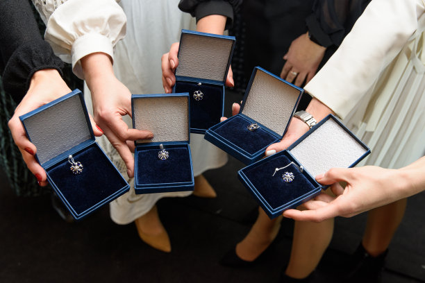 银首饰吊坠在蓝色礼品盒。女性的手拿着一个有银坠饰的盒子图片下载