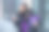 手里拿着紫色礼物的年轻女子在户外使用智能手机。图片下载