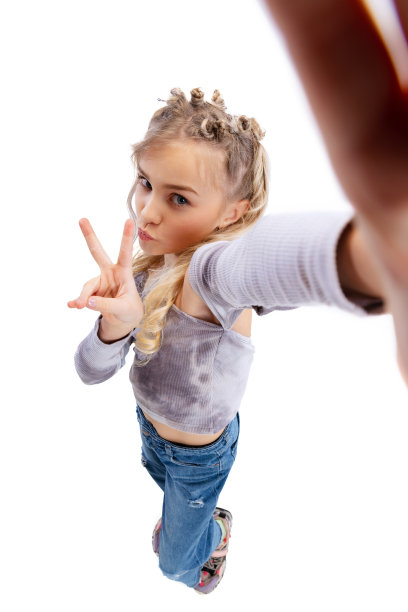 镜头前的美丽的小女孩，穿着休闲衣服的孩子在灰色的工作室背景下自拍。图片下载