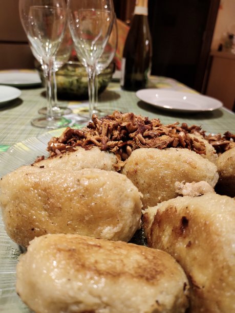 填满蘑菇和洋葱的土豆片。白俄罗斯的国菜。炒鸡油菇的配菜。桌上有蔬菜沙拉和香槟杯。素食者。图片下载