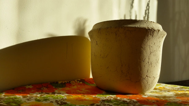 家用装饰，白色的陶器花瓶在花卉桌布上。客厅装饰。风格,设计。高质量的照片图片下载