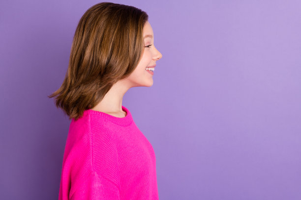 简介侧面照片年轻快乐开朗好心情可爱的女孩看copyspace孤立在紫色的背景图片下载