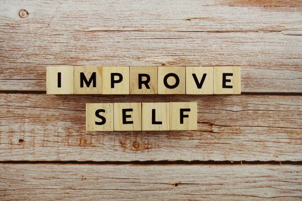 改善自己的单词字母在木制背景图片下载