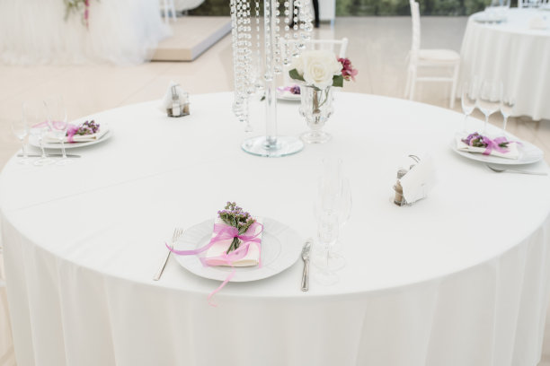 用鲜花装饰的宴会接待桌:盘子、刀叉和酒杯。图片下载