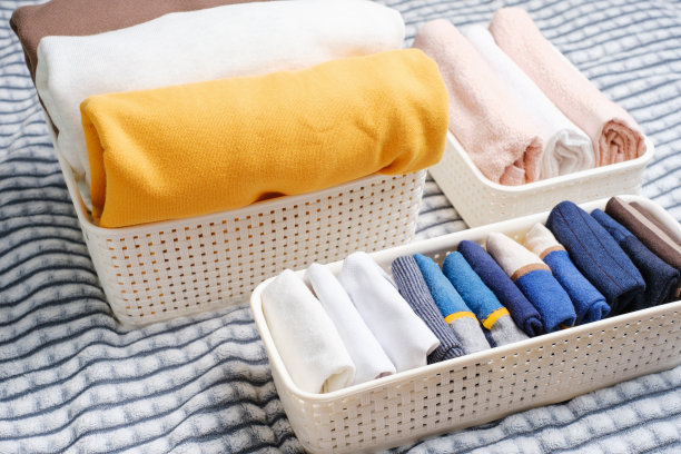 衣服在灰色背景的塑料容器上，空间组织概念。图片下载